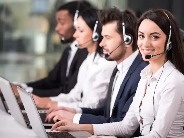 Professional call centres agents providing customer support using headsets and laptops, showcasing teamwork and service efficiency.