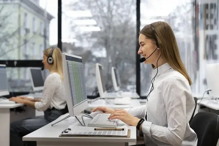 Female call center representative engaging in real-time customer support at a modern workstation, enhancing the digital customer service experience.