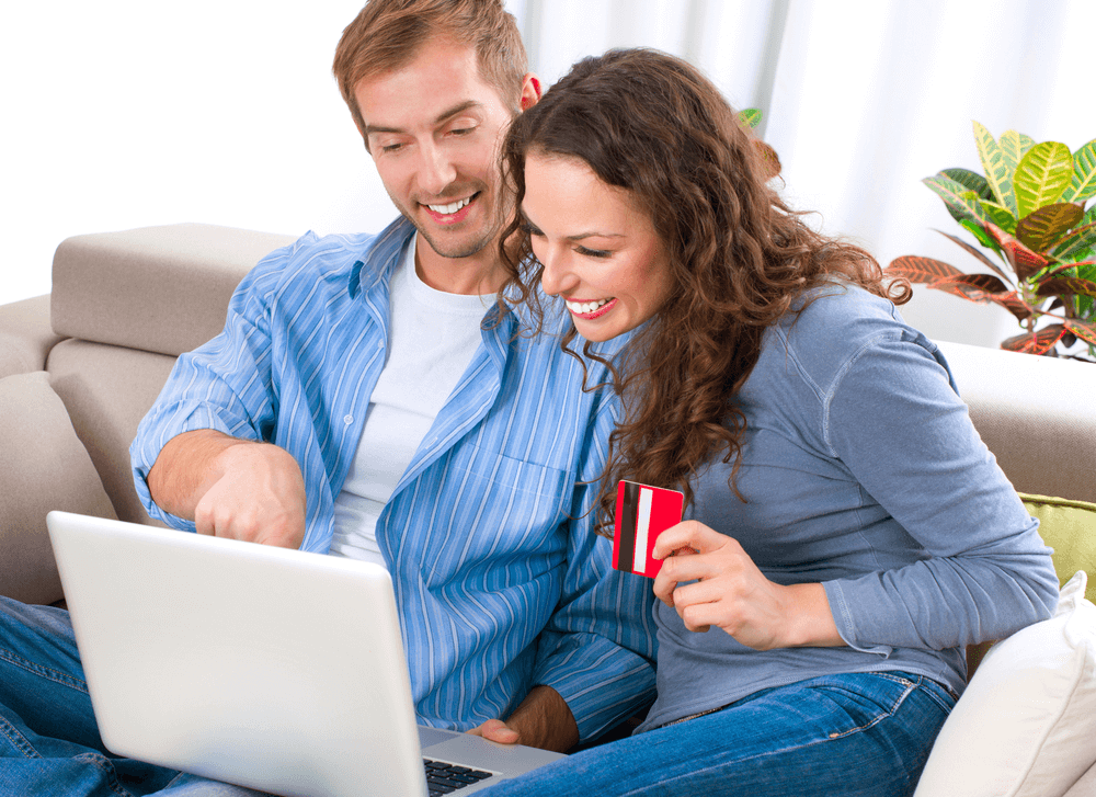 Two consumers confidently and happily making an eCommerce purchase together with a credit/debit card online.