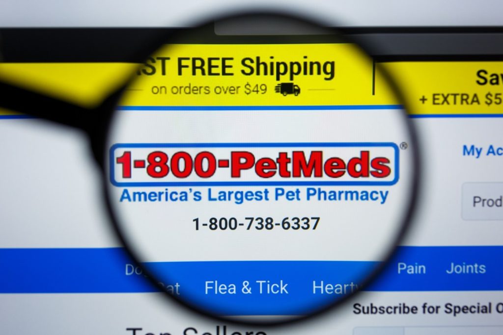 A magnifying glass demonstrates a close-up magnification of the business, PetMed Express, Inc.'s, international toll-free number, 1-800-PETMEDS.