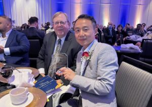 Jackie Xu, fonuder and CEO of Callnovo Contact Center - poses for the camera in the Markham 32nd Annual Business Excellence Awards ceremony, displaying the plaque that Callnovo received for becoming a top 3 finalist in the Global Business Excellence category.