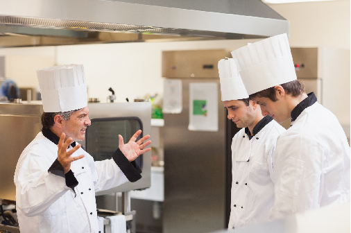 An angry head chef scolds his kitchen team because they weren