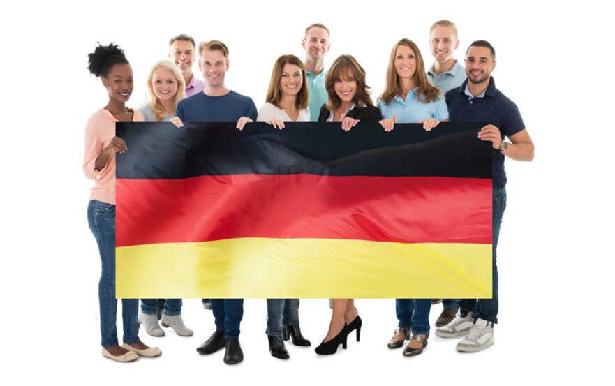 A diverse group of customer service professionals holding a German flag, symbolizing the importance of German customer service and cultural adaptation.