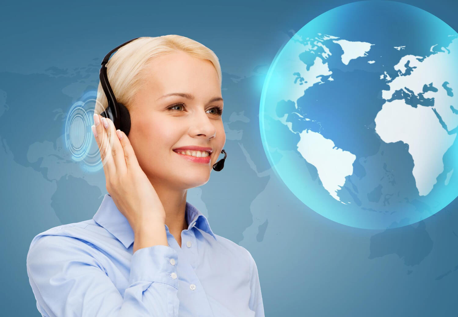 A smiling female customer service representative provides strategically-positioned call center services via a headphone; the picture shows a background that includes globe, demonstrating that regionally-placed call centers can support global business expansion.