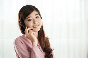 A female Vietnamese customer service agent that provides stellar Vietnam outsourcing solutions smiles for the camera.